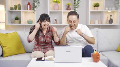 The-couple-rejoicing-at-what-they-see-on-the-laptop.